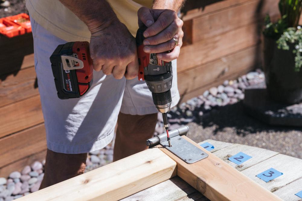 Using a drill to attach the hinges to the new Z-frame.