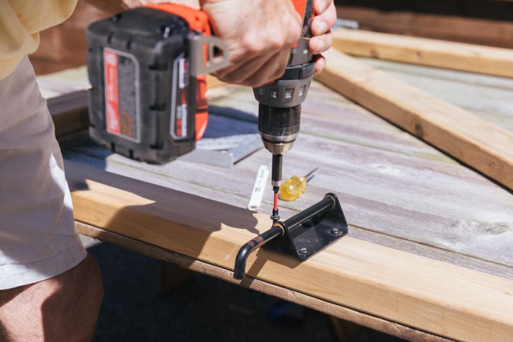 Using a drill to attach the latch to the new Z-frame.