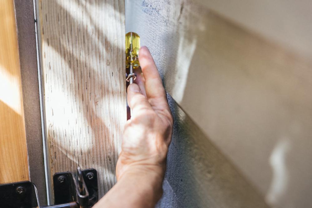 Attaching a screw eye between the fence and the house.