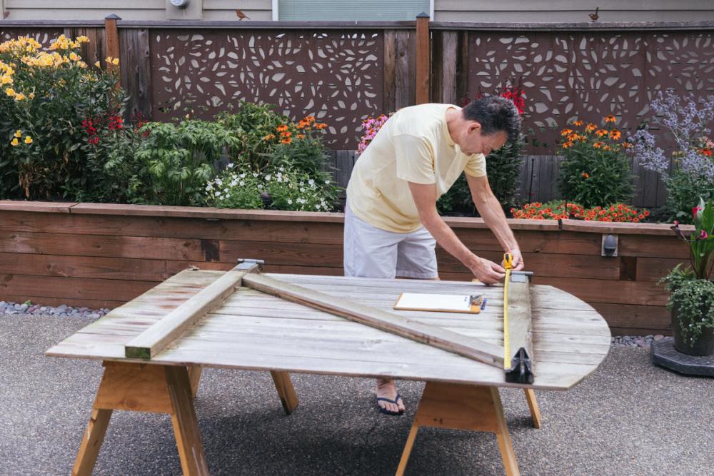 Using a tape measure to measure the Z-frame of the fence gate.