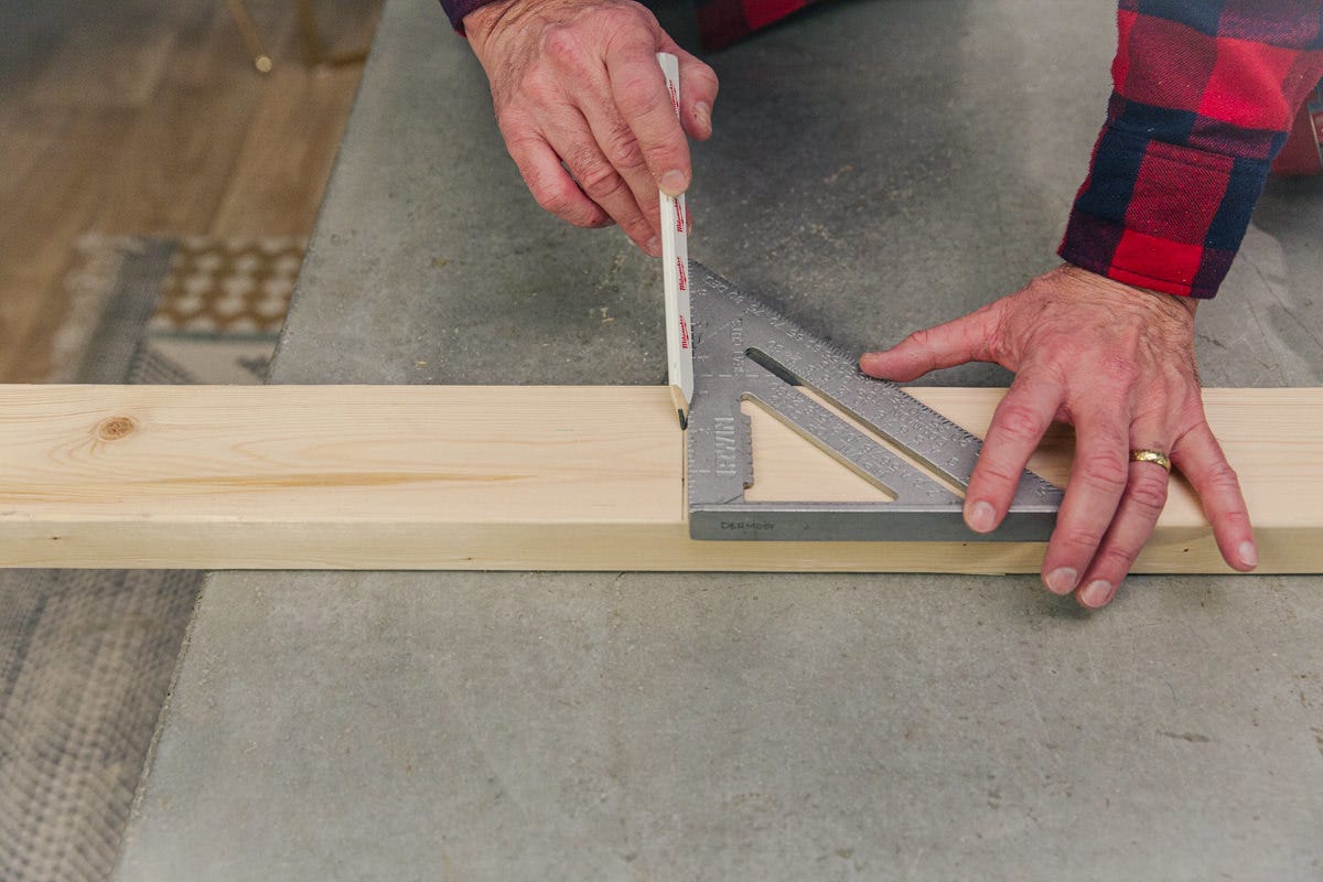 measure wood cut Measuring and marking board with speed square and pencil.