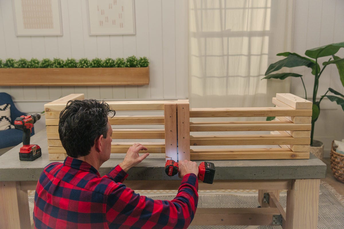 wood bench braces Driving screw to attach top brace to wood DIY expandable bench assembly.